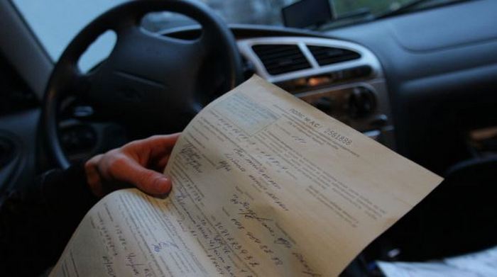 траховой полис в руках у человека в машине